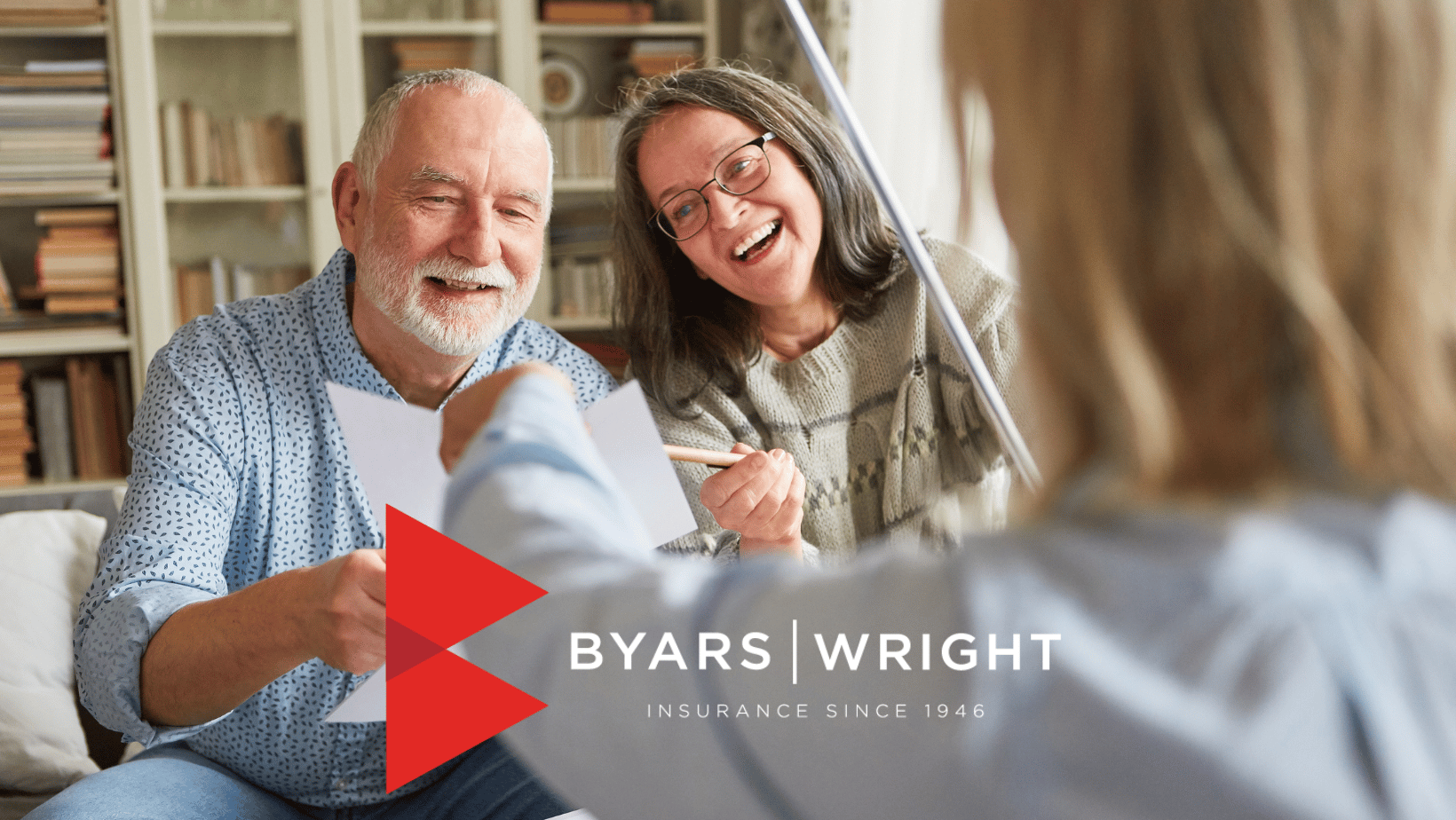 couple smiling while signing business insurance